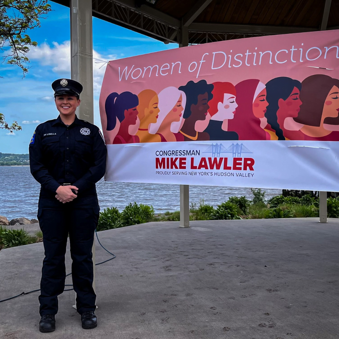 Firefighter Alison Lisella Next To Women of Distinction Sign
